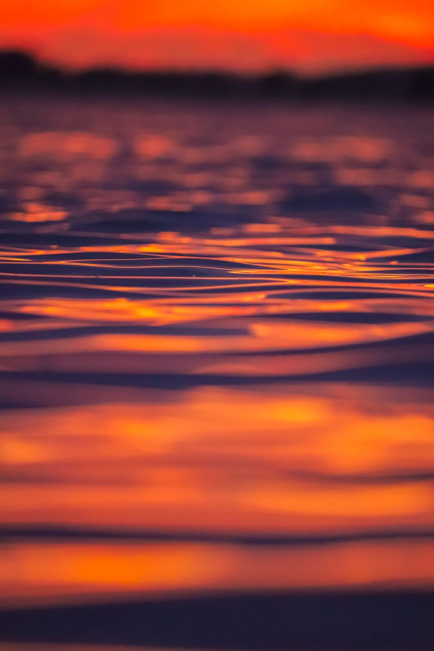 a close up shot of a body of water during sunset